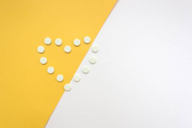 İlaç şişe ve beyaz hap üzerine sarı pastel renkli arka plan döktüm. İlaç ve reçeteli ilaç düz arka plan yattı. Opioid salgın.