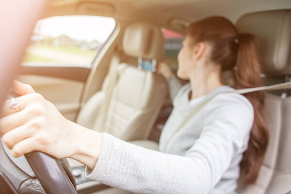 The child in a safety seat near to mother who sits on forward sitting of the car. Baby in a child car seat. safe transportation of children. family travels