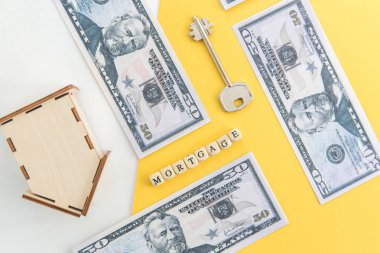 Mortgage, kredi ve ev satın alma. Ev, para, beyaz ve sarı izole arka plan üzerinde anahtar modeli. Metin, flatlay için boş alan