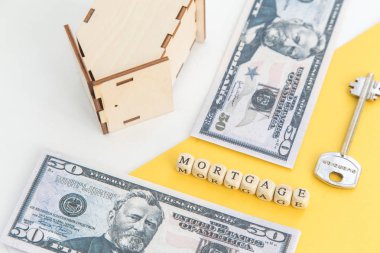 Mortgage, kredi ve ev satın alma. Ev, para, beyaz ve sarı izole arka plan üzerinde anahtar modeli. Metin, flatlay için boş alan