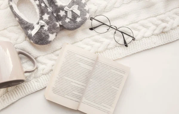 Confort à la maison et soirée d'hiver. lunettes vintage soft focus, livre. vue de dessus des pantoufles de la maison, une tasse sur un tapis tricoté flatlay. apprentissage, rédacteur en chef, correcteur, écrivain — Photo