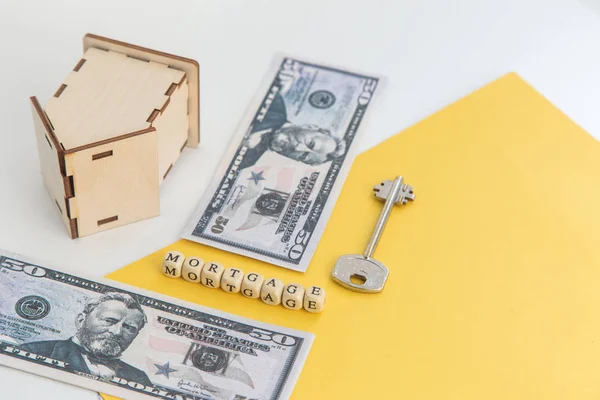 Mortgage, kredi ve ev satın alma. Ev, para, beyaz ve sarı izole arka plan üzerinde anahtar modeli. Metin, flatlay için boş alan