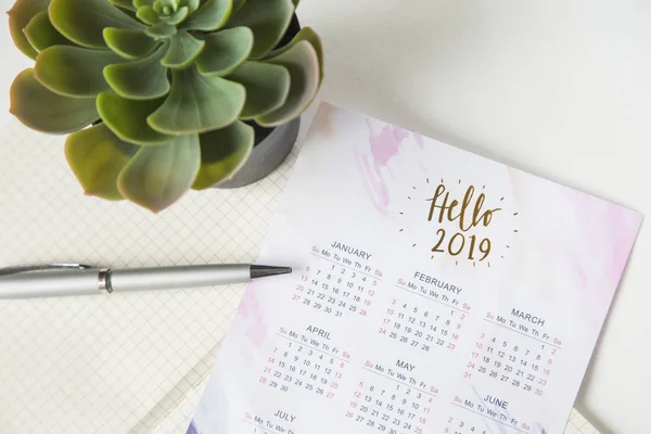 Calendário para 2019 na mesa de escritório em um caderno. Planos e metas para o novo ano. Layout de vista superior no fundo branco — Fotografia de Stock