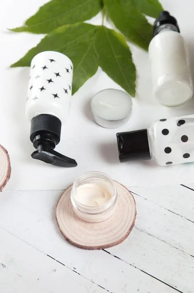 Beauty flat lay with spa cosmetic bottles, jar of cream, succulent leaves and saw cut wood. Top view, minimalism, fltlay