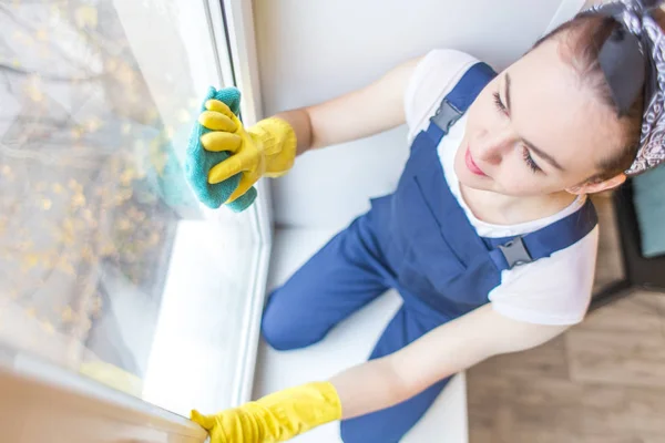 Cleaning service with professional equipment during work. professiona carpet dry cleaning, sofa dry cleaning, window and floor washing. women in uniform, overalls and rubber gloves.