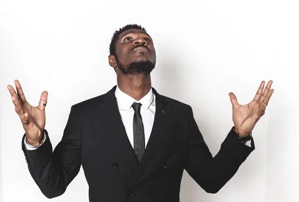 Portrait d'un jeune Afro-Américain en costume d'affaires. émotions sur le visage. l'homme lève les mains et regarde le ciel, le ressentiment, le stress. isolé sur fond blanc, espace libre pour le texte — Photo