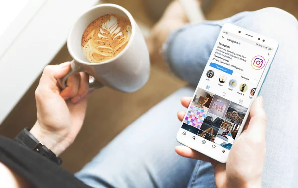 Ufa, Rusya 20 Ocak 2019: WOMANS ellerinin mockup görüntü barda uyluk ve kahve bardağı boş ekran ile beyaz cep telefonu tutarak