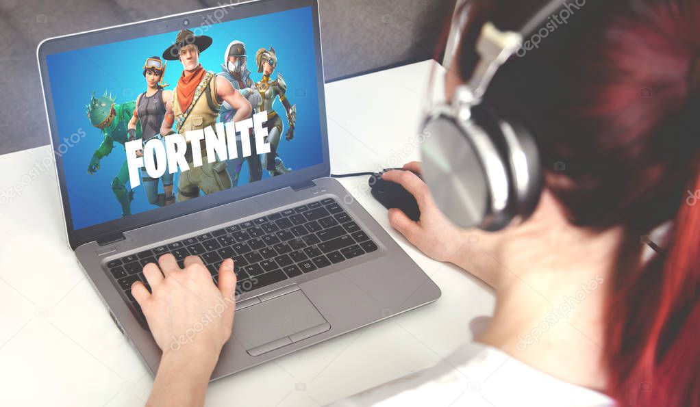 Ufa, Russia - February 7, 2019: Woman on laptop playing Fortnite battle royale.