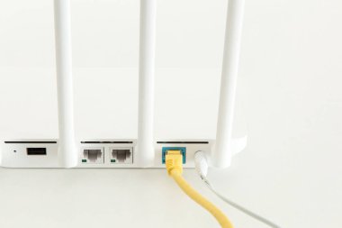 Beyaz arka planda beyaz WiFi yönlendirici. Minimalizm. Yama kablosu