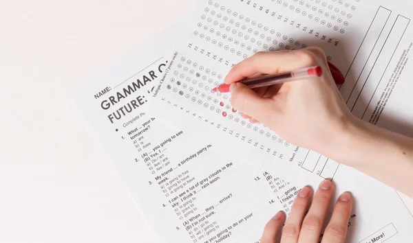 Teste de múltipla escolha Inglês na tabela.Mulher faz um exame de admissão — Fotografia de Stock