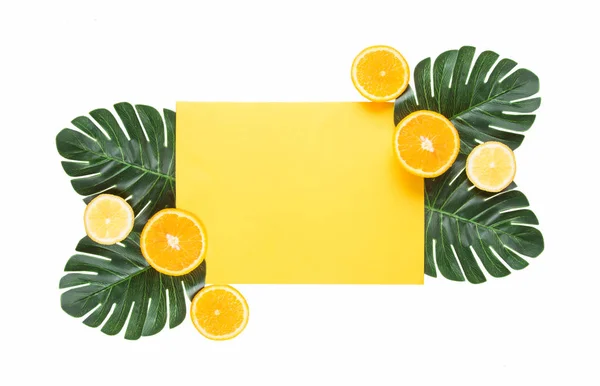 Creative hipster tropiska löv och apelsin frukt bakgrund med kopierings utrymme på ljus bakgrund. Tropiskt koncept. — Stockfoto