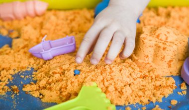 Kinetik kum ile oynayan bir çocuk kızın elleri. ince motor becerilerini geliştirme