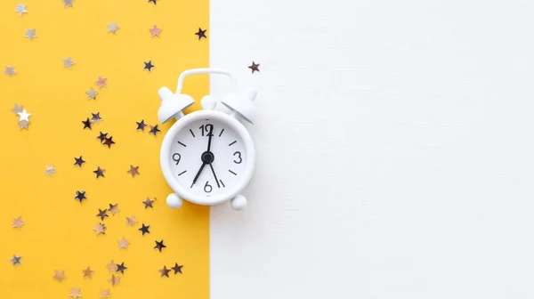 Horloge de table blanche, alarme sur fond jaune, vue de dessus. Bonjour. Bonjour. Minimalisme, flatlay — Photo