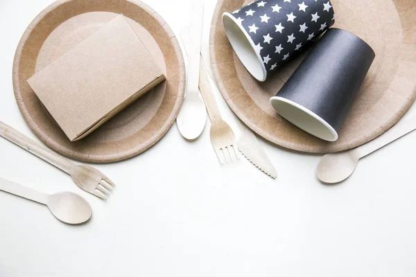 Plats jetables respectueux de l'environnement fait du papier sur fond de marbre blanc. Cuillères, fourchette, couteaux, assiette avec des tasses en papier. concept de recyclage — Photo