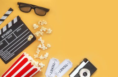 Sinema parti konsepti. film biletleri, clapperboard, pop mısır ve sarı bir arka plan 3d gözlük. Düz yatıyordu