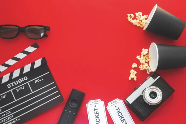 Concepto de fiesta de cine. entradas de cine, clapperboard, maíz pop y gafas 3d en un fondo rojo. Puesta plana —  Fotos de Stock