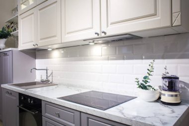 Modern mutfak, beyaz tuğladan duvarlar, ahşap tezgah lavabo ve fırın..