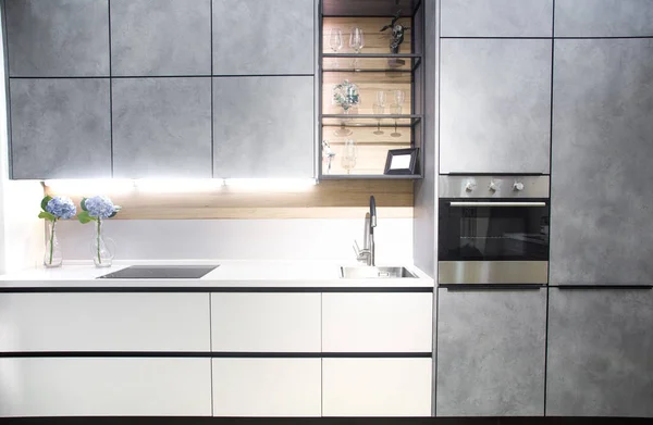 Interior de la cocina moderna con paredes de ladrillo blanco, encimeras de madera con un fregadero incorporado y una cocina . — Foto de Stock