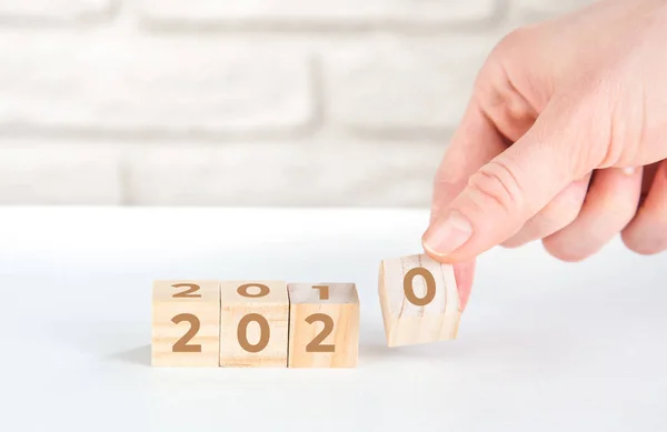 Women's hands hold wooden cubes 2020. new goals for next year — ストック写真