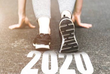 Spor üniformalı güzel bir kız etrafta koşuşturuyor. Sağlıklı bir yaşam biçimi, aşılanmış bir figür. Spor ayakkabıları yakın plan, 2019 'u bitir. Yeni yıla başla 2020 planlar, hedefler, hedefler