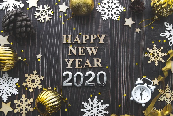 Feliz Año Nuevo 2020 flatlay composición. Juguetes de Navidad y copos de nieve blancos sobre un fondo de madera negro — Foto de Stock
