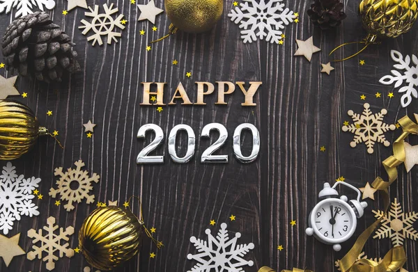 Happy New Year 2020 flatlay composition. Christmas toys and white snowflakes on a black wooden background — Stock Photo, Image