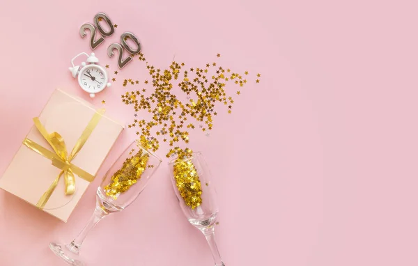 Flatlay composição de Natal em um fundo rosa pastel. Copos com champanhe, confete. Véspera de Natal 2020 . — Fotografia de Stock