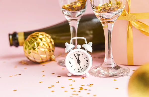 Composición navideña sobre fondo rosa pastel. Vasos con champán, confeti y reloj. Nochebuena 2020 . — Foto de Stock