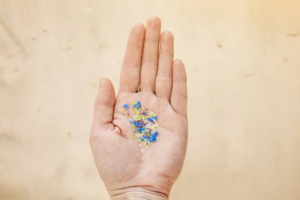 Mikroplast i handen på en man på stranden. Miljöföroreningar och vatten mikro plast. — Stockfoto