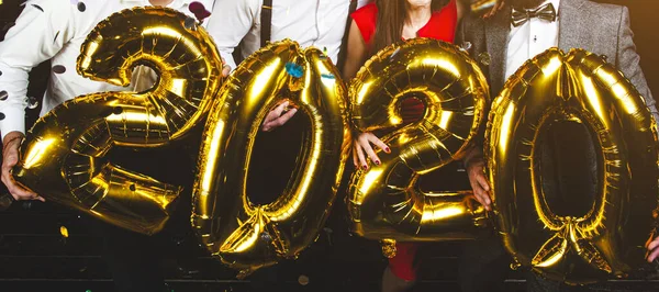 people at a corporate party holding balloons 2020. New Year celebration. Club party with friends