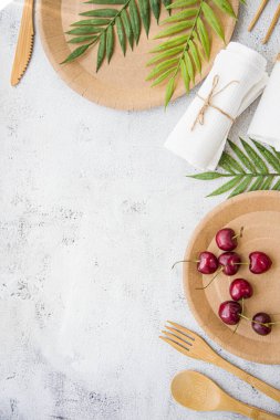 Çevre dostu kullan-at yemekler beyaz mermer arka planda kağıt ve bambu yaptılar. Sarılmış kaşıklar, çatal, bıçaklar, kağıt bardaklı tabaklar. Geri dönüşüm konsepti. Sıfır atık, boşluğu dikey kopyala