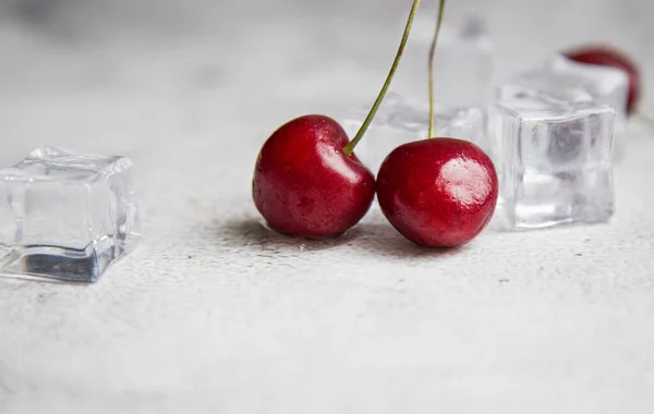 Top view berry cherries and ice cube on a gray concrete background. Summer frash concept — Stock Photo, Image