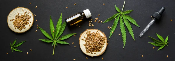 düz kompozisyon üst görünümü. Marihuana yaprakları, kenevir yağı ve kenevir tohumları. CBD yağlı cam şişe, THC tentür. Kozmetik CBD yağı