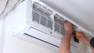 Havalandırma tamiri. Usta klimayı teftiş ediyor. filtre temizliği