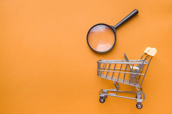 オンラインショッピングと検索 オレンジの背景にスーパーマーケットのトロリーバスケット 宅配便 — ストック写真