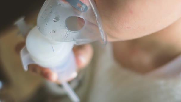Boğazı ağrıyan hasta kadın yüzünde maskeyle solunum yapıyor. Hasta hasta kendini nebulizör ile iyileştiriyor. — Stok video