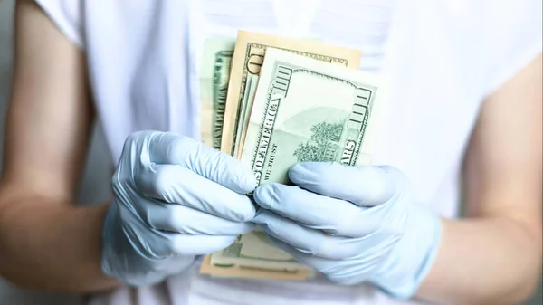 woman in gloves in a store counts money. quarantine coronovirus covid-19.