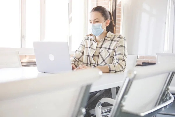 Kaukaska kobieta z medyczną maską dla coronavirus covid-19 ochrona pracuje w biurze z laptopem — Zdjęcie stockowe