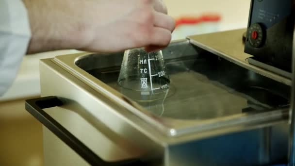 Glass flask with chemical liquid substance in hands scientific worker — Stock Video