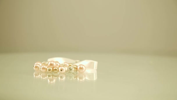 Pearl bracelet isolated. Pearl thread. Bracelet of pink pearls on a white background — Stock Video
