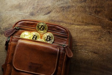 Bitcoins parası ahşap masadaki kahverengi deri çantalarda çok parlak olarak saklanır. İş ve ticaret için tasarım kavramı