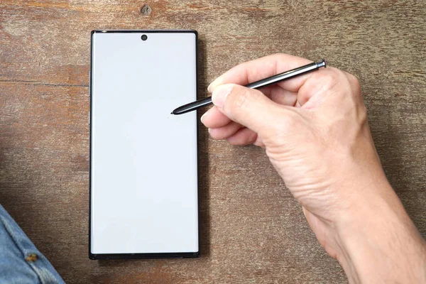 Adamın eli yeni bir akıllı telefon yazıyor.