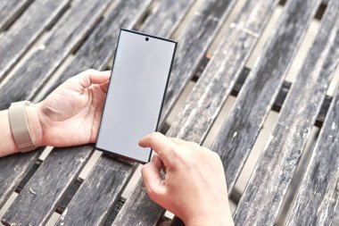 El masada bir cep telefonu ile oynuyor               