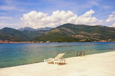 Yaz tatili. Sahilde güzel manzara ile bir şezlong. Karadağ, Kotor Körfezi (Adriyatik Denizi), Tivat
