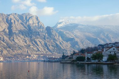 Güzel kış Meditarranean manzara. Karadağ, Kotor Körfezi, karla kaplı dağ Lovcen ve Prcanj şehir görünümünü