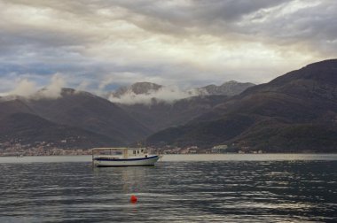 Güzel Mediterranean bulutlu kış gününde manzara. Dağlar, deniz ve su üzerinde bir balıkçı teknesi. Karadağ, Adriyatik Denizi, Kotor Körfezi