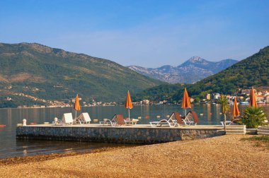 Yaz plaj tatil. Güzel Mediterranean manzara plaj şemsiyeleri ile güneşli yaz günü. Kotor Körfezi Karadağ, Adriyatik Denizi, görünümünü Tivat city yakınındaki