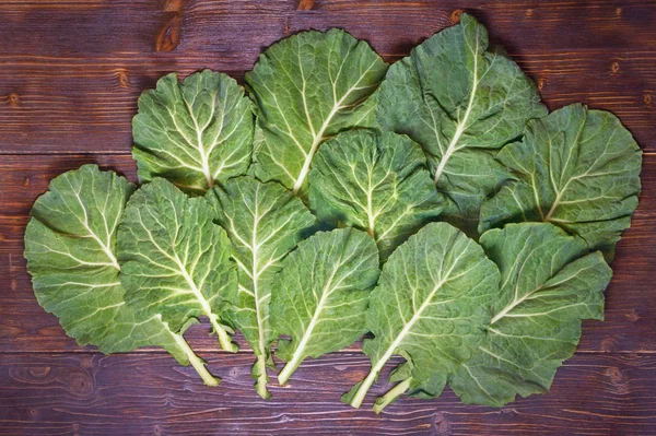 (Collard zöldek, collards) - Rastan népszerű leveles zöldségek, a balkáni fogásokat. Rusztikus sötét háttér, lapos feküdt — Stock Fotó