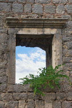 Beyaz bulutlar ile mavi bir gökyüzü görülebilir bir pencere ile eski bir imha bina duvar