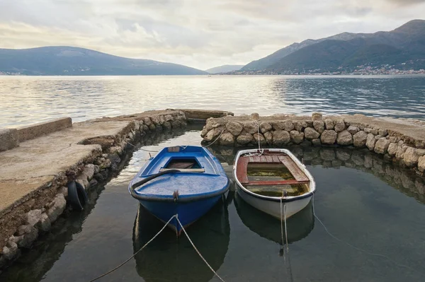 Two old fishing boats in a small harbor on cloudy autumn day.  Montenegro, Adriatic Sea, Bay of Kotor near Tivat city — Stock Photo, Image